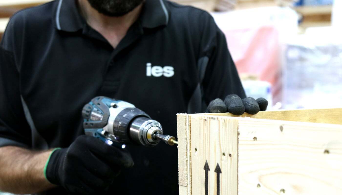 Technician building a custom wooden export crate