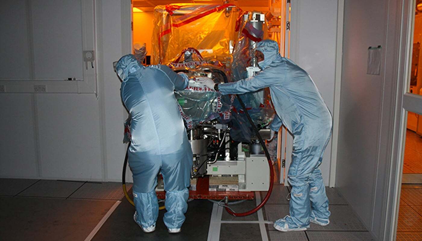 Specialist team moving sensitive equipment inside a cleanroom