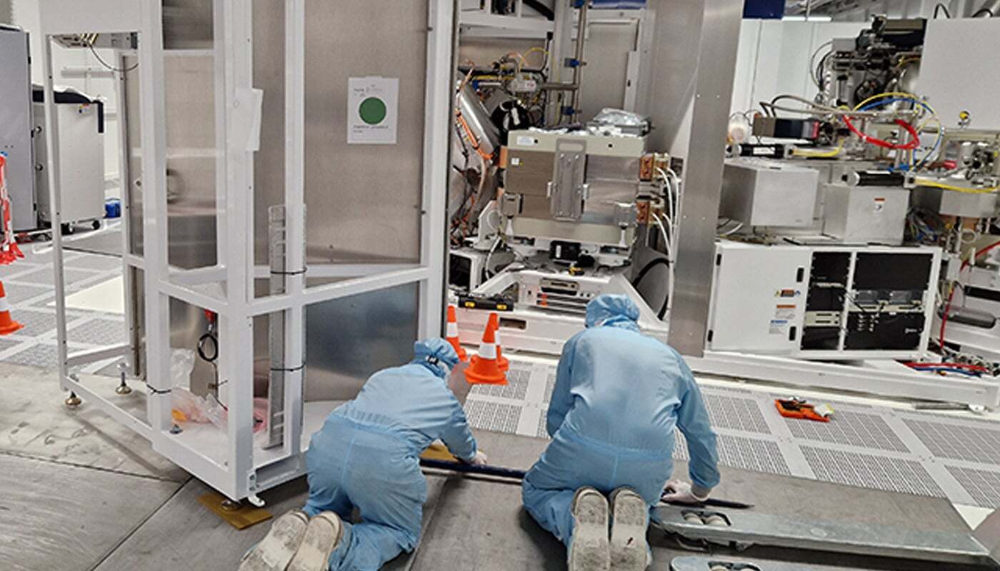 Engineers installing high-technology equipment in a cleanroom
