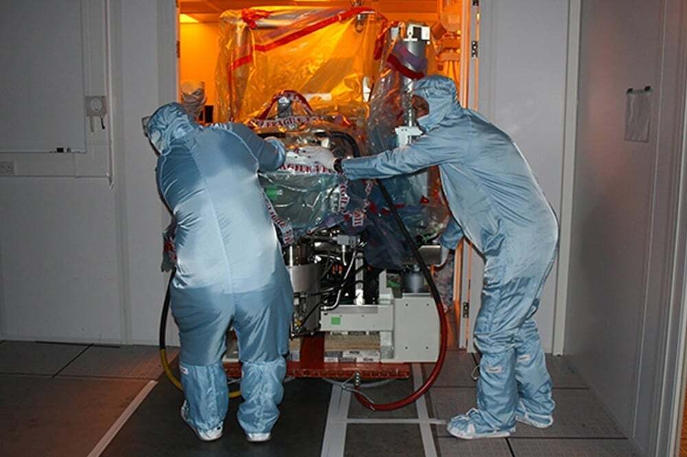 IES engineers moving equipment inside a cleanroom
